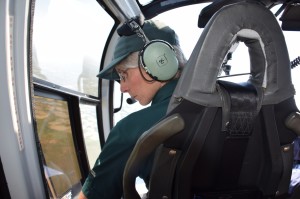 Figure 2. Scanning the wetlands below for whooping cranes. Photo of Sharon Irwin, Resource Management Officers at WBNP. (Sharon was the Survey Lead/Data Recorder for the Survey.) Photo by Jane Peterson / ©Parks Canada /Wood Buffalo National Park