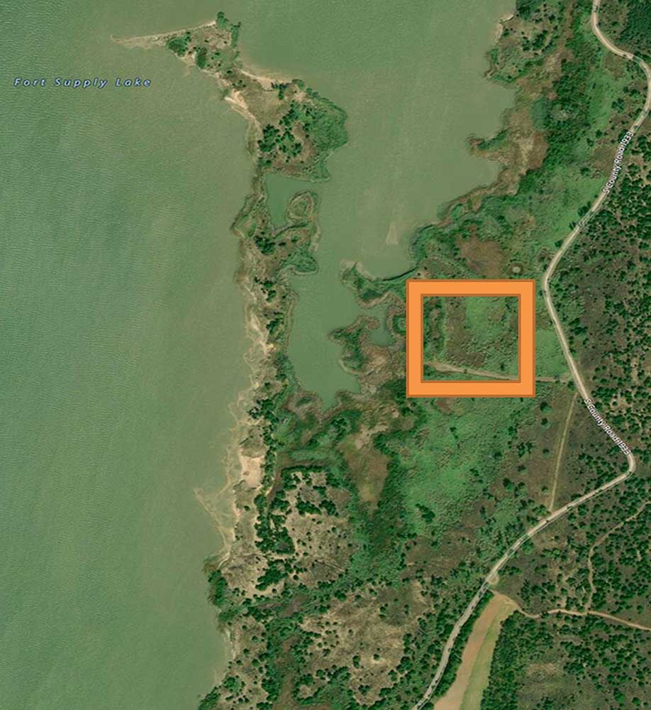 Fort Supply Lake, Oklahoma Figure 3. This photo identifies a 3 to 4acre site near the lake that could be developed into a shallow water“stopover habitat” (3 inches to 6 inches deep) for Whooping Cranes and other wild creatures. The vegetation in the area could be treated with herbicide and burned when dry. A low level berm as outlined can be constructed around the developed pond to hold shallow water for a “stopover habitat”. This small wetland would operate independently from the water levels in the lake. Photo by Chester McConnell, Friends of the Wild Whoopers.